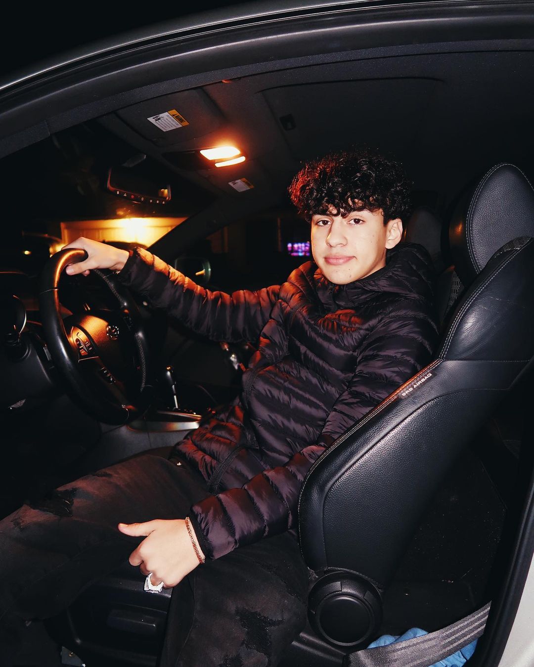 Marc Gomez sitting in a car and posing for a picture